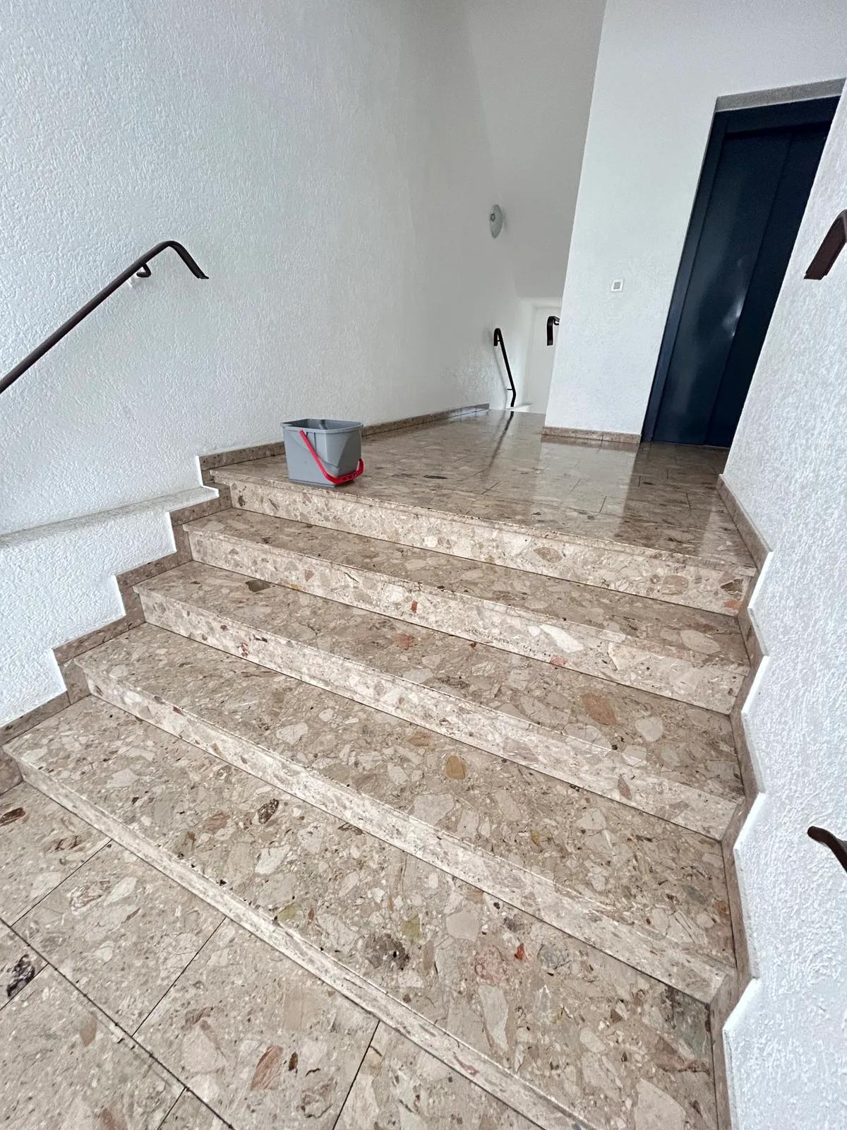 Frisch gereinigtes Treppenhaus mit Steintreppe — Hausmeisterservice von Lomi-Bau